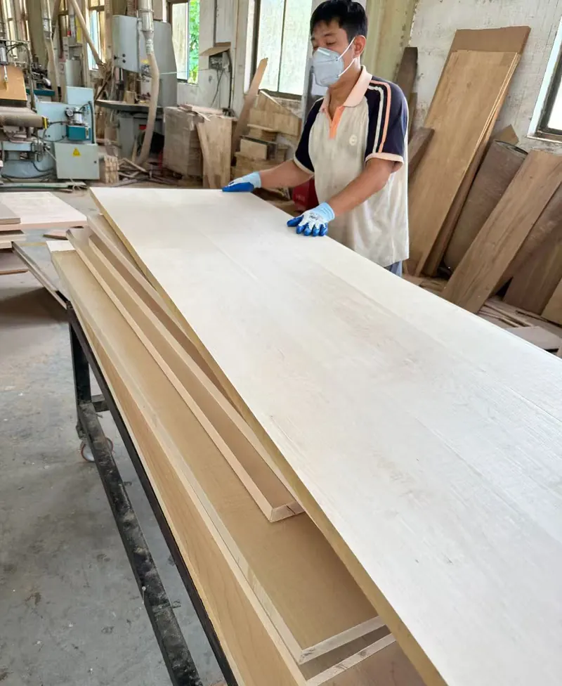 Worker sanding and quality checking wood countertop panel